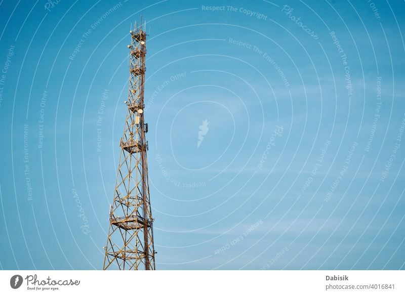 Communication tower with antennas against blue sky cell broadcast radio telecommunication network mobile technology wireless transmitter metal phone frequency