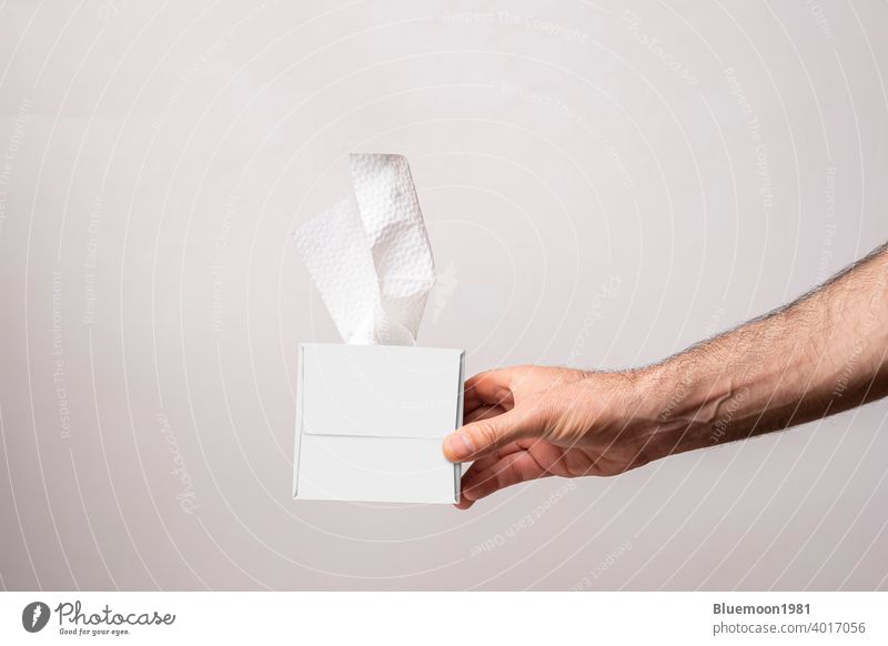 Male hand holding a cubical tissue box on white background mock-up editable change paper isolated napkin template facial product soft cardboard cleaner