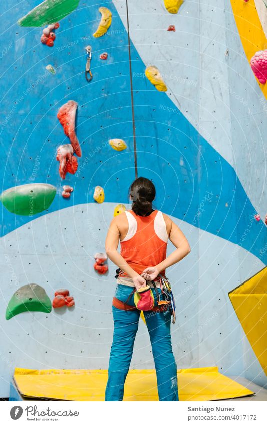 Woman getting ready for rock climb indoors. woman climber climbing rock climbing hands unrecognizable back view magnesium bag white wall gym young training