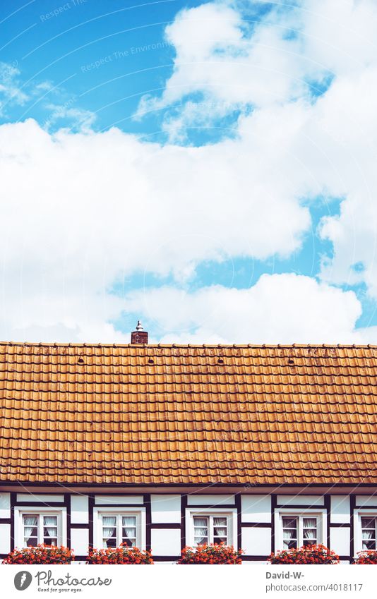 Roof of a half-timbered house under a bright blue sky Half-timbered house Blue sky Beautiful weather Window box Cozy Architecture Sky Clouds Summer