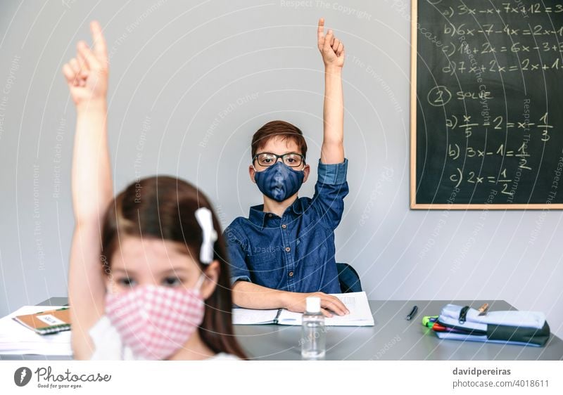 Students with masks raising hands at school new normal coronavirus student participating face mask safety people girl boy epidemic education classroom smart