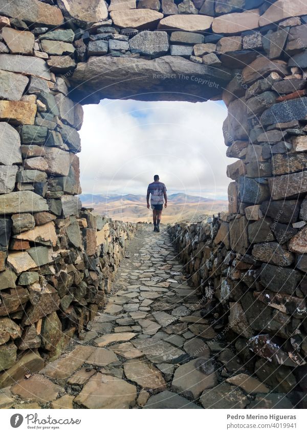 Man walking on the stone way in the Sicasumbre astronomic viewpoint. Fuerteventura summer travelling mountain chain atlantic ocean spain many-coloured blue sky