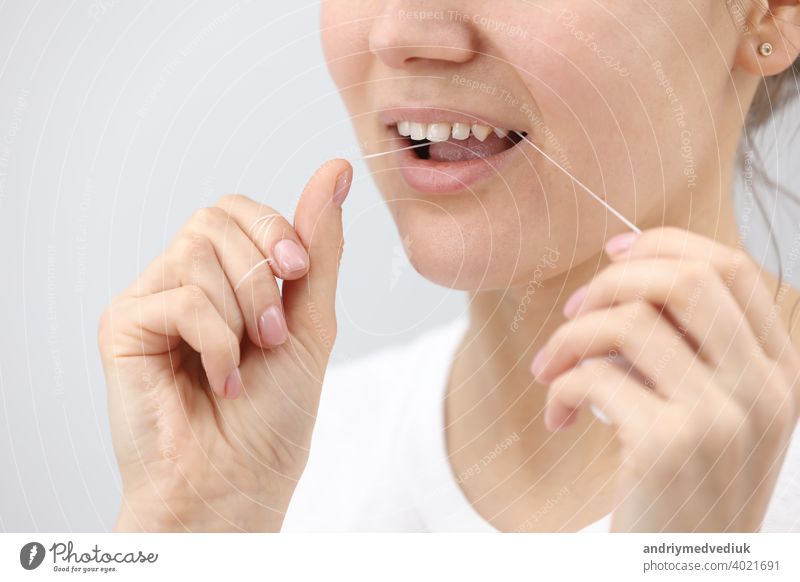 Oral hygiene and health care. Smiling woman use dental floss white healthy teeth. oral women mouth clean tooth young face smile fresh girl hand happy healthcare