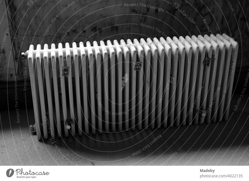 Discarded traditional radiator in the dark cellar of a farmhouse in Rudersau near Rottenbuch in the district of Weilheim-Schongau in Upper Bavaria, photographed in classic black and white