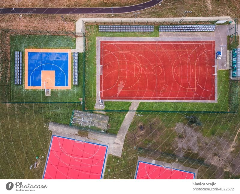 Colorful basketball, volleyball and soccer grounds. A red ,orange and blue colored outdoor sports grounds for basketball, handball and soccer from above.