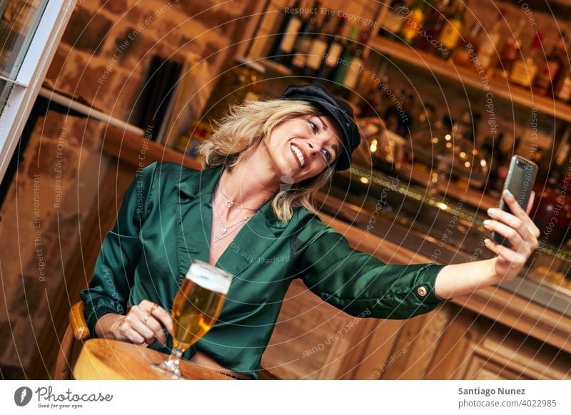 Woman taking a selfie at a bar. couple adult woman happy female restaurant lifestyle caucasian beautiful happiness drink smile fun love joy celebration dating