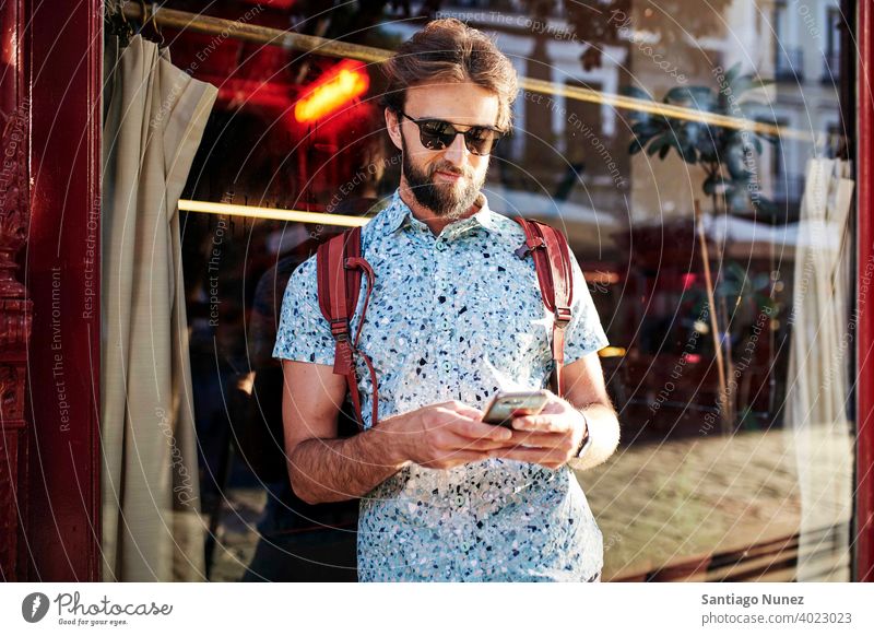 Man looking at his phone on the streets. adult happy lifestyle caucasian happiness smile fun love joy leisure cheerful laughing date smiling enjoyment 30s