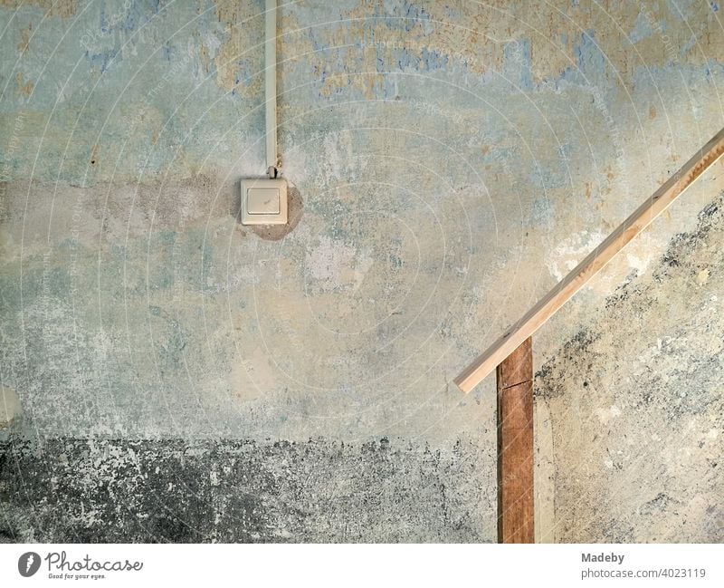 Light switch and improvised staircase railing in a staircase in need of renovation on a farm in Rudersau near Rottenbuch in the district of Weilheim-Schongau in Upper Bavaria