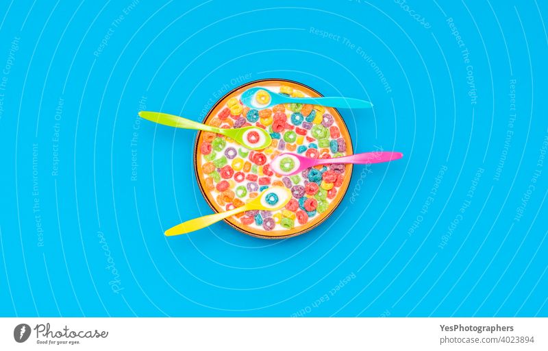 Multicolored cereals and spoons in a bowl with milk, top view on a blue background. above view breakfast cereal bowl childish colorful comfort food copy space
