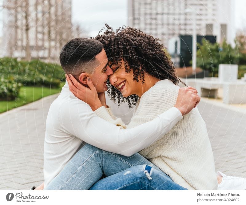 Shallow focus of a romantic young couple hugging on a pavement under a cloudy sky kissing outdoors shallow woman romance together female happiness people adult
