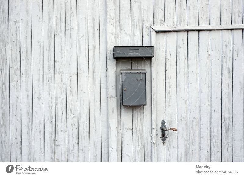 Entrance door in an old light grey wooden barn door of a farm in Wettenberg Krofdorf-Gleiberg near Giessen in Hesse, Germany Wooden gate Goal Barn Door