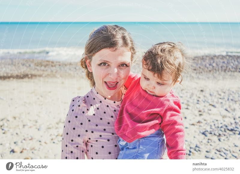 Happy family moment of a young mom enjoying a day on the beach with her baby love holidays happiness lifestyle sun sunny summer trendy fashion mother parenthood