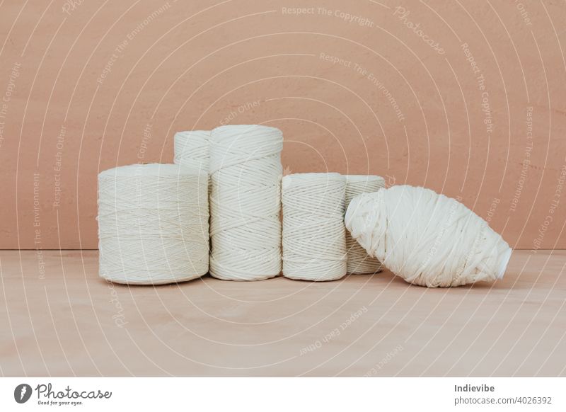 Set of white knitting yarn spool on beige background. Different size cotton threads. spools sewing isolated string craft color textile tailor bobbin fiber
