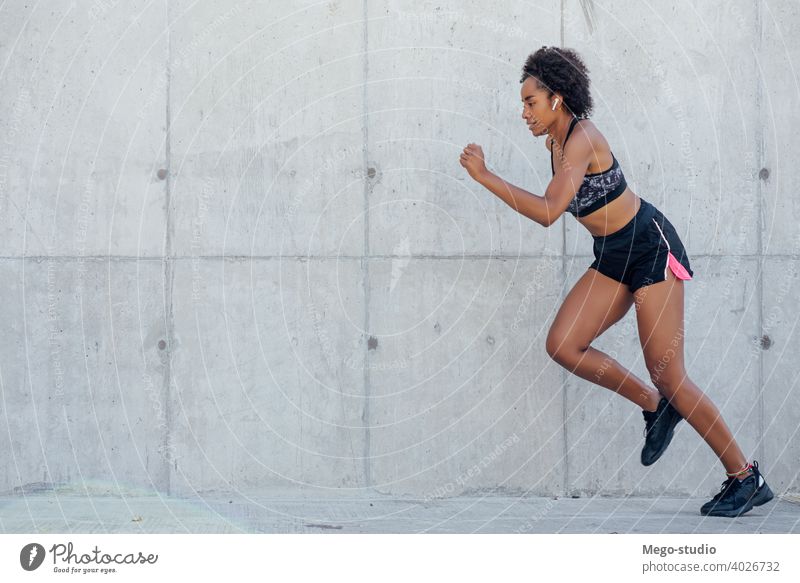 Afro athlete woman flexing and showing muscles. Stock Photo by megostudio