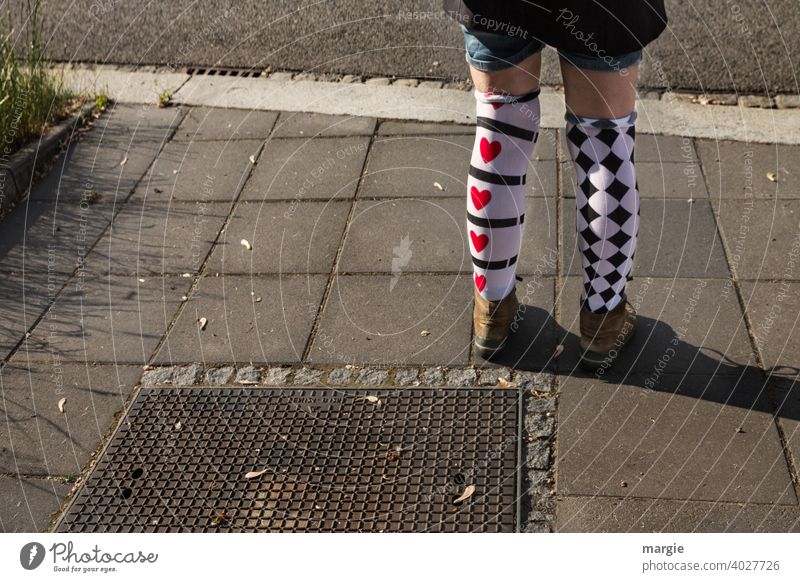 AST10 l A girl wears two differently patterned stockings with red hearts and black checks Stockings Heart diamonds Pattern pattern mix short pants Footwear