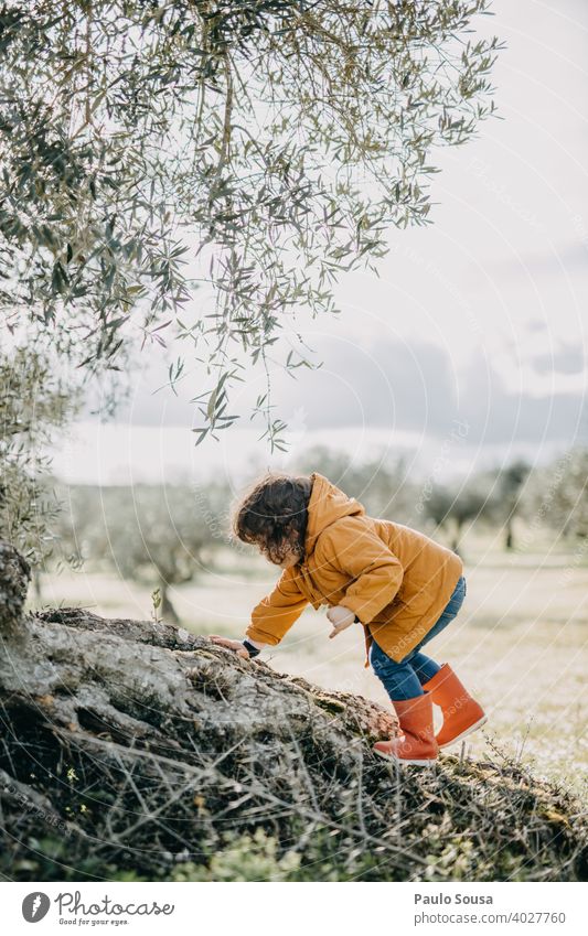 Child with red rubber boots climbing Climbing Red Rubber boots outdoors Nature Spring explore Adventure Exterior shot Playing Human being Rain Infancy Joy Boots