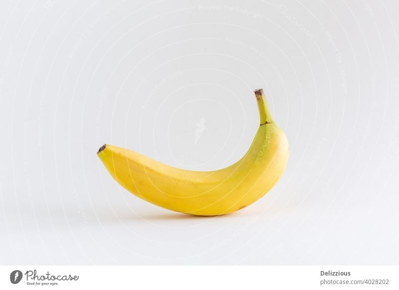 A single banana on a white background, with copy space abstract appetizing banana yellow calcium concept dessert diet eat eating energy food food and drink
