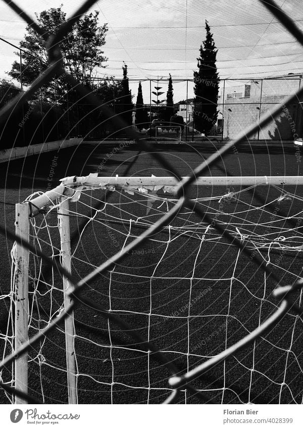 View through a fence onto an open sports field with opposing soccer goals spectators Insight Hard court Coating Playing field parameters training ground