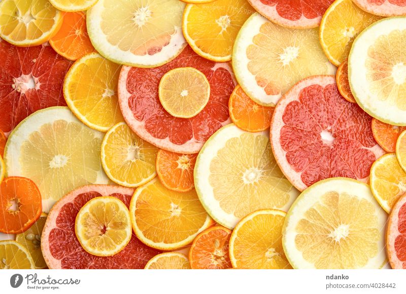 citrus fruits cut into round pieces: orange, grapefruit, lemon, tangerine juicy natural fresh healthy background food yellow ripe vitamin sweet slice closeup