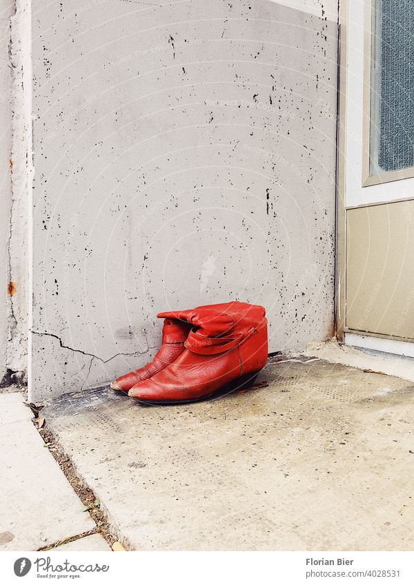 A pair of red lady's boots to be given away and no longer worn, parked in front of a house entrance. Red Footwear Boots High heels bootees Leather shoes Carried