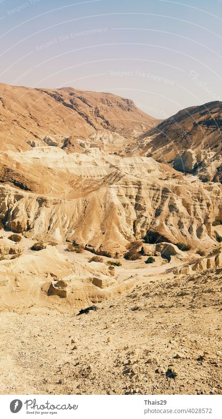 Beautiful landscape of Israeli Judean Desert mountains, with dry riverbed, popular hiking trail winding between rugged rocky cliffs towards the Dead Sea israel