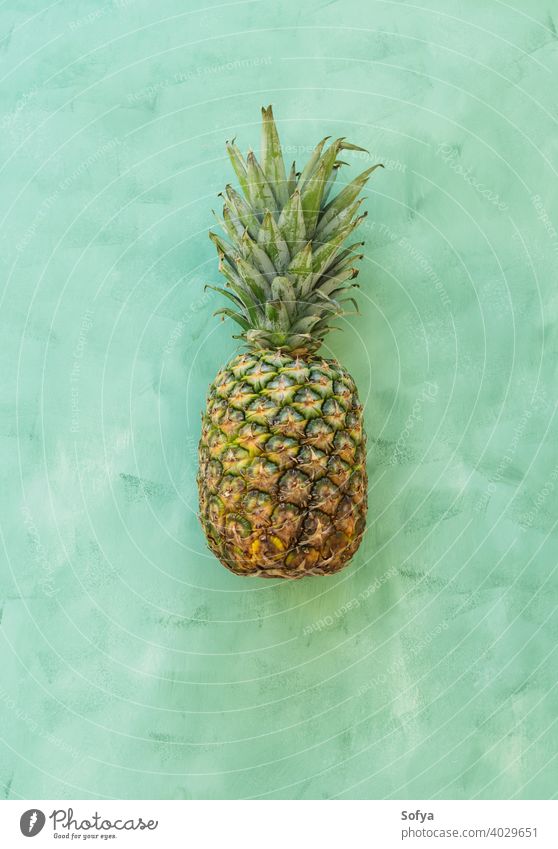 Whole pineaple fruit on green background, top view pineapple ananas ripe fresh summer organic texture close yellow group stem sweet delicious food healthy whole