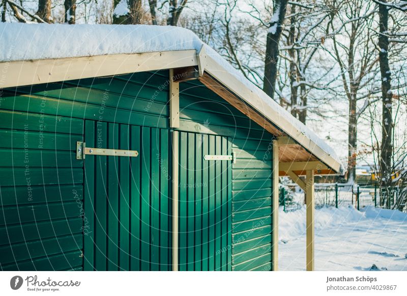 green wooden hut in winter with snow in forest Manmade structures Roof House (Residential Structure) Wooden facade Wooden hut Snow Goal door Forest