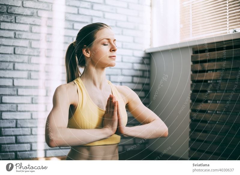 A blonde girl is resting after a fitness class and meditating. The concept of sports and a healthy lifestyle. Yoga, meditation young beautiful position lotus