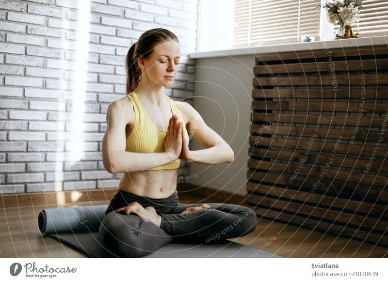 A beautiful girl sits in the lotus position and meditates. Yoga, fitness, meditation. Healthy Lifestyle Concept meditating young woman yoga lifestyle exercise