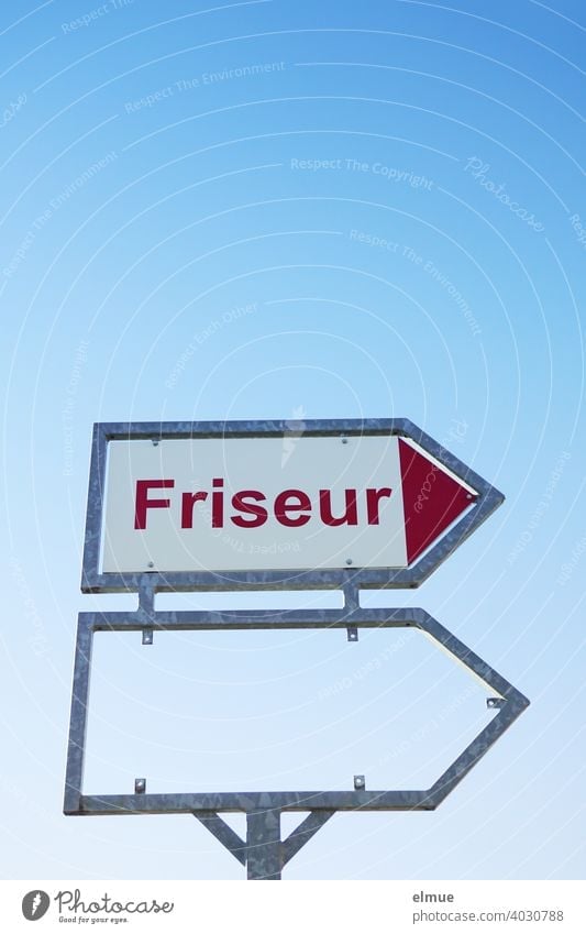 Sign with red print "Friseur" and an empty frame for another sign in front of a blue sky / hairdresser's appointment Hairdresser hair stylist