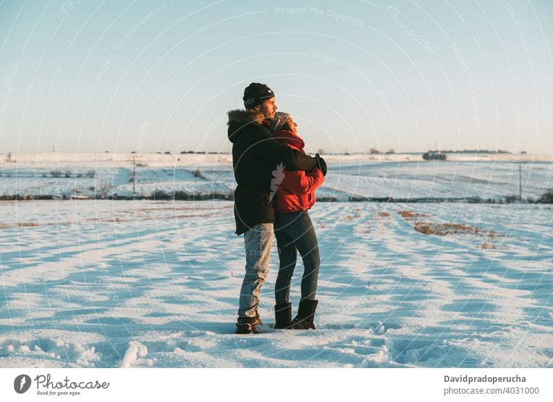 Couple hugging in snowy field couple kiss winter countryside love romantic together relationship affection fondness embrace amorous tender bonding cuddle