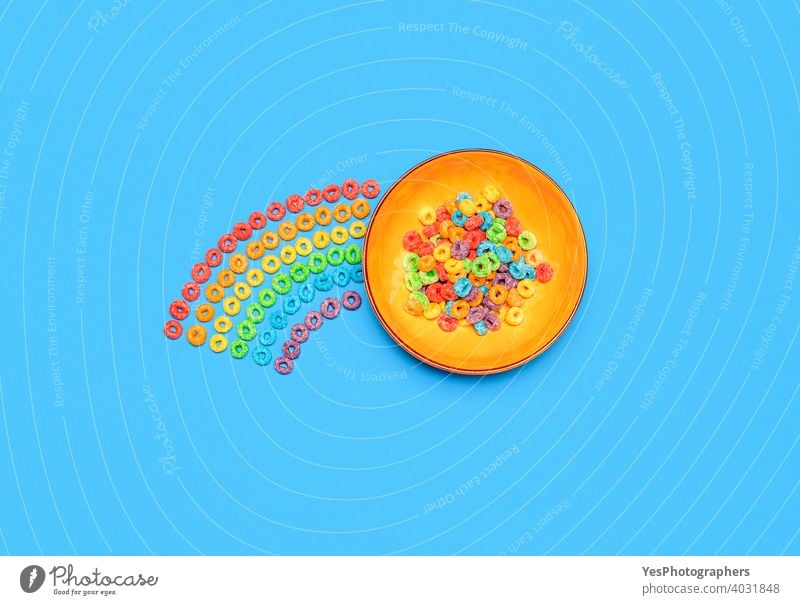 Cereal bowl isolated on blue background. Rainbow fruit-flavored ring cereals, top view above view assorted breakfast cereal bowl cheerful childhood childish