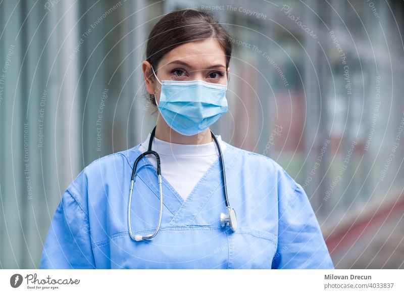 Young worried stressed anxious female EMS key worker doctor portrait  outside hospital - a Royalty Free Stock Photo from Photocase