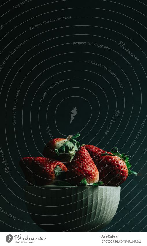 A minimal shot of a bunch of strawberries in a bowl over a dark background with copy space strawberry colorful minimalism wallpaper horizontal dieting colours