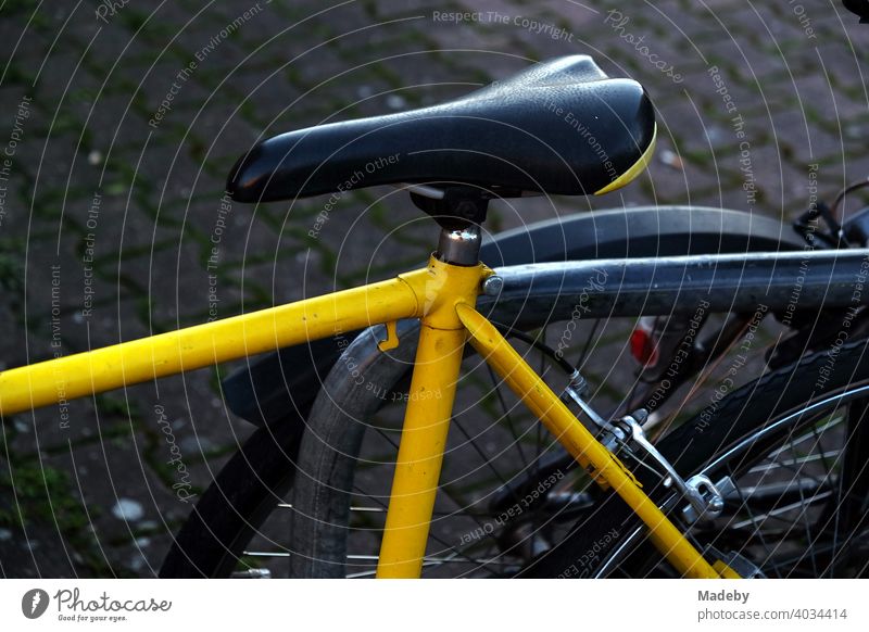 Racing bike with yellow frame and narrow saddle in the evening at the Hanauer Landstraße in the Ostend of Frankfurt am Main in Hesse Bicycle Wheel Racing cycle
