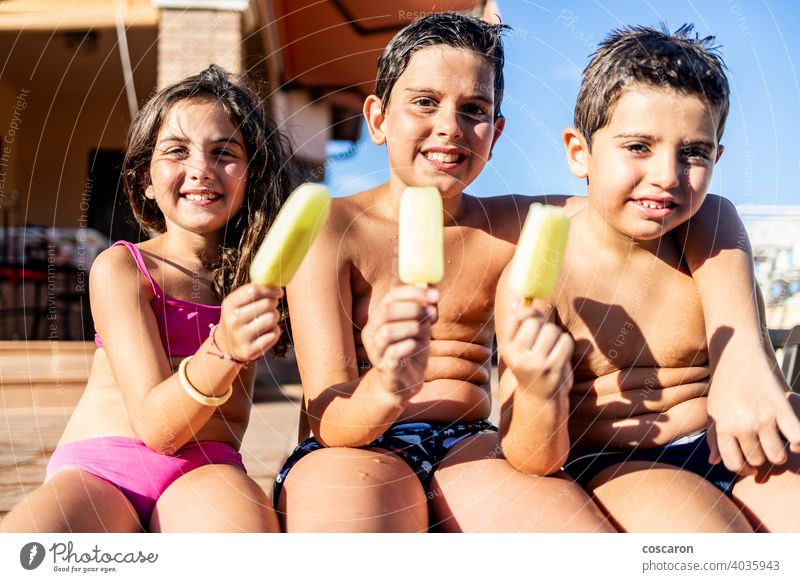 Three funny kids eating an ice lolly boy brother caucasian cheerful child childhood children cream daughter day dungaree enjoy exterior family food fresh frozen