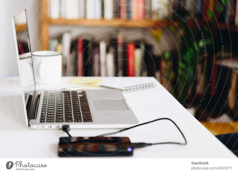 Close up detail view of a white work desk with laptop, hard drive and coffee office design workspace home business mug cup workplace background creative plant