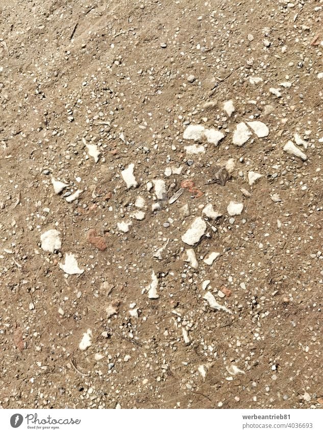 Pebbles on the brown dirty path pebbles mud park parkland stone stones garden gardening construction site background structure texture white material sand coast