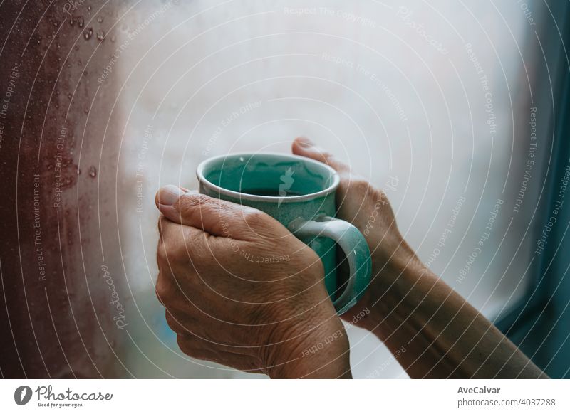 Two old hands grabbing a fast tea during a cold dayTwo old hands grabbing a fast tea during a cold day drink cup water hot woman kitchen background person pour