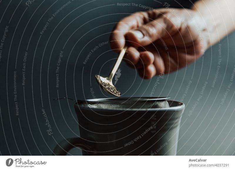 A old hand preparing a tea over a dark background with copy space and dark tones drink cup water hot woman kitchen person pour kettle beverage green female