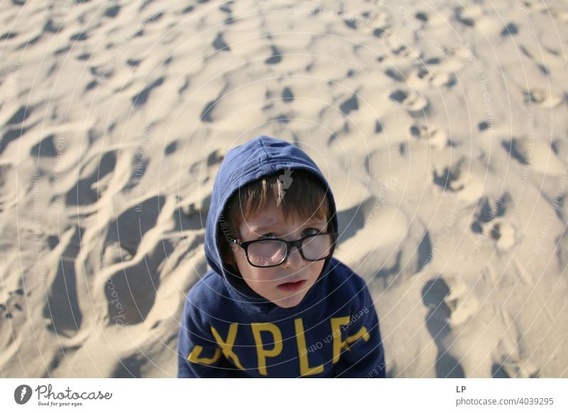 beautiful child wearing glasses and a hoodie  looking very serious into the the camera puzzled Perplexed sceptical scepticism doubts Doubt hestitate uncertainty