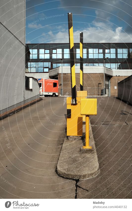 Yellow barriers at the entrance to a modern hospital in summer in Paderborn in East Westphalia-Lippe Control barrier Highway ramp (entrance) Parking level
