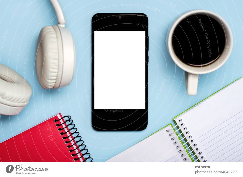smartphone with white screen for copy space with notebooks,headphone and cup of coffee office telecommunication networking message social banner lifestyle app