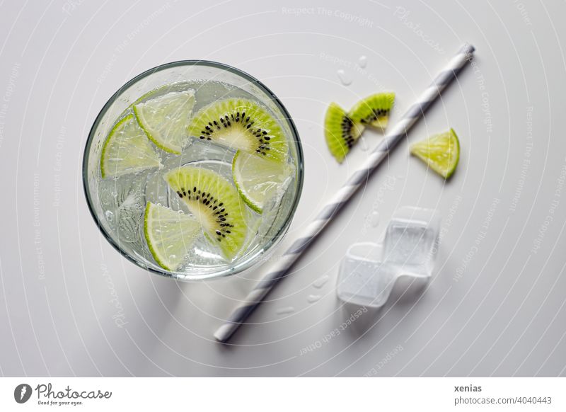 Flavored soft drink with kiwi, lime and ice cubes. Paper drinking straw is ready. Beverage Cold drink Kiwifruit Ice cube Refreshment Summer aromatic water