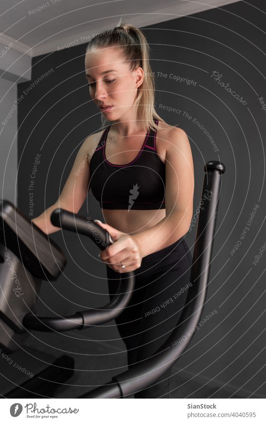 Woman Exercise Elliptical cardio running workout at fitness gym endurance people exercise training body elliptical trainer power treadmill athletic sport