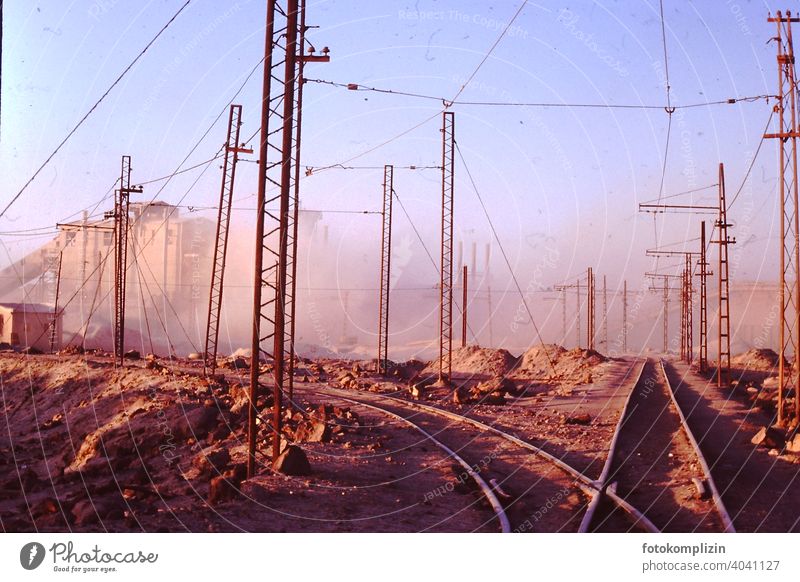 Railway tracks on factory site in the desert railway tracks rails Factory Factory site Industrial area Industry Electricity Transmission lines Cable Technology