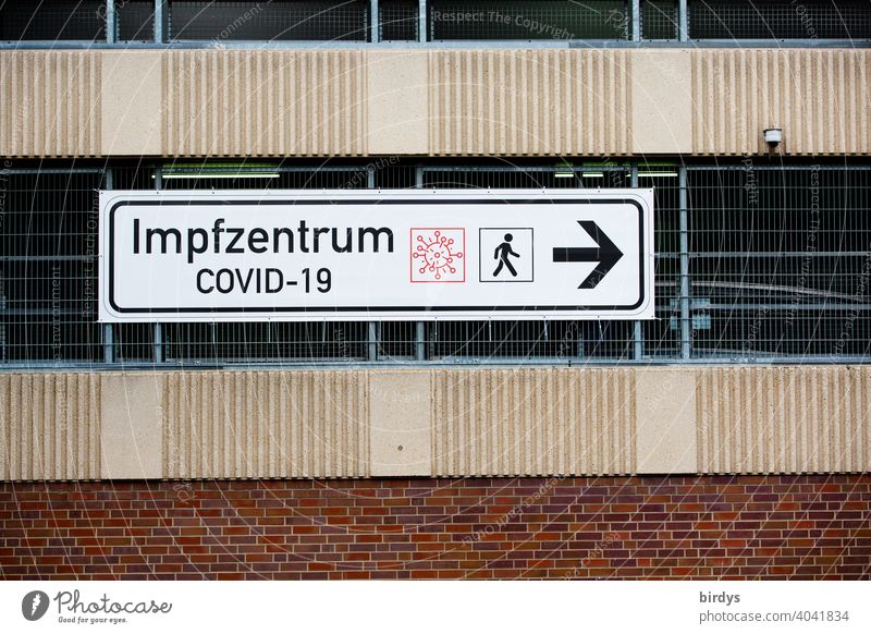 Signpost to the Covid-19 vaccination center. Vaccination center ,big sign at a parking garage vaccination centre covid-19 inoculate sb. pandemic Road marking