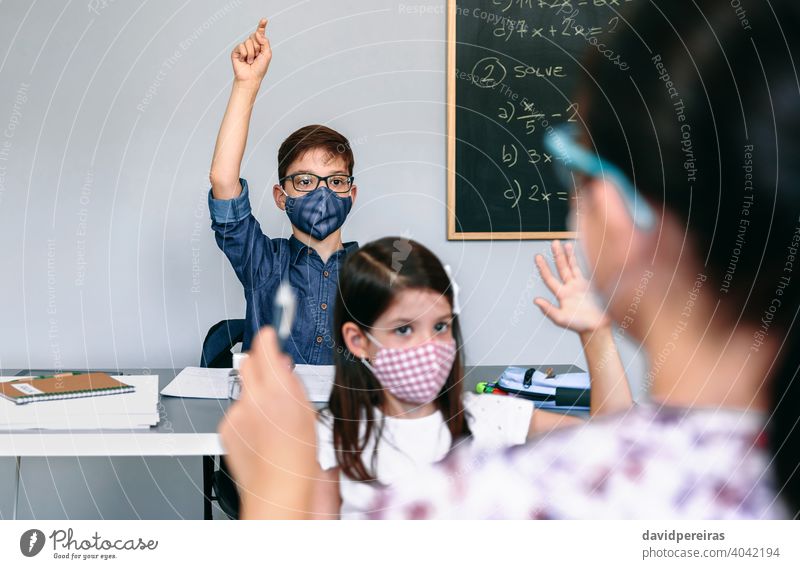 Students with masks raising hands at school coronavirus face mask new normal participating female teacher safety people girl boy epidemic education woman
