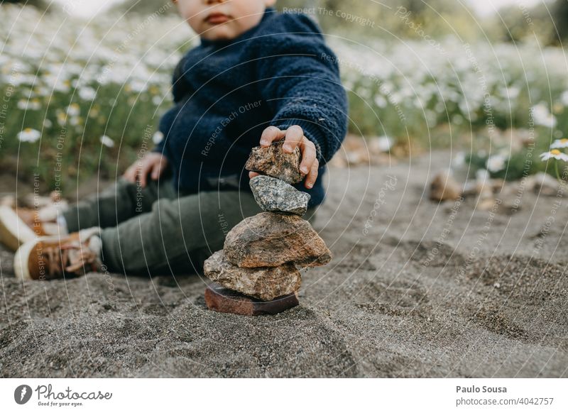 Child playing with rocks outdoors childhood Caucasian 1 - 3 years mid section explore Rock equilibrium pile Exterior shot Happiness Playing Day Lifestyle