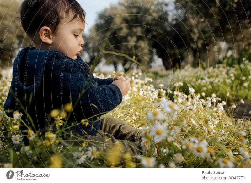 Child playing in the park childhood Spring Flower Curiosity explore Happy Park 1 - 3 years Authentic Happiness Day Caucasian Colour photo Nature Exterior shot